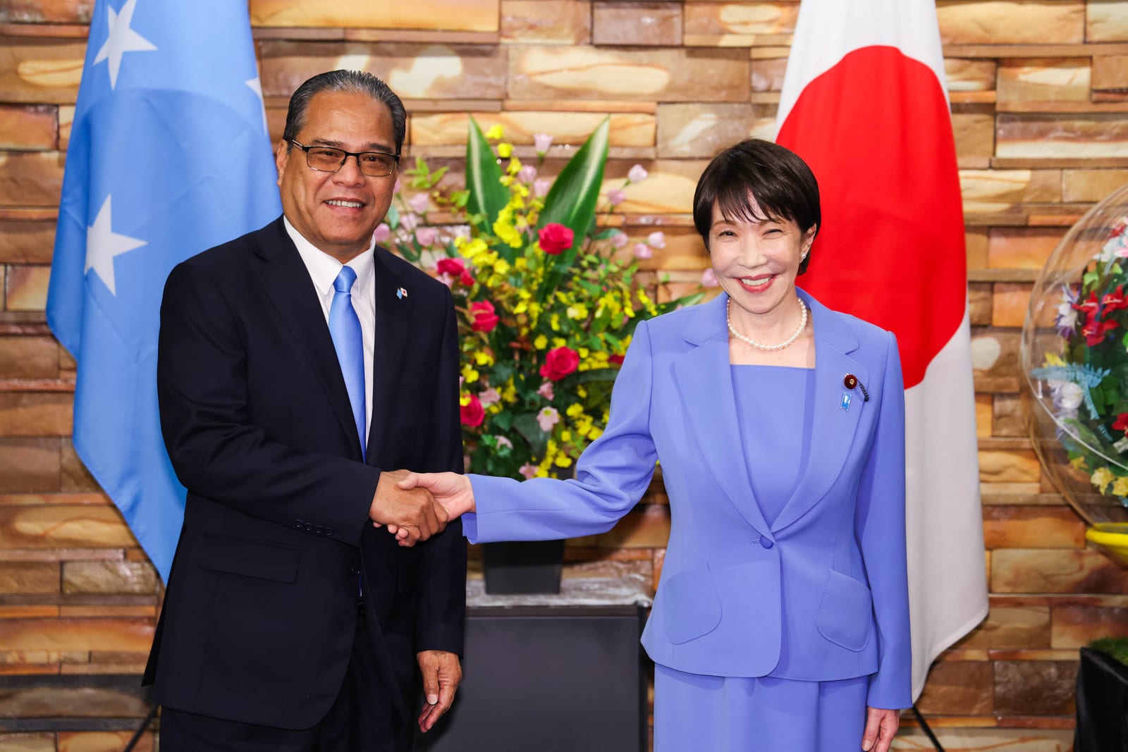 首相官邸で握手する高市首相とミクロネシア連邦のシミナ大統領